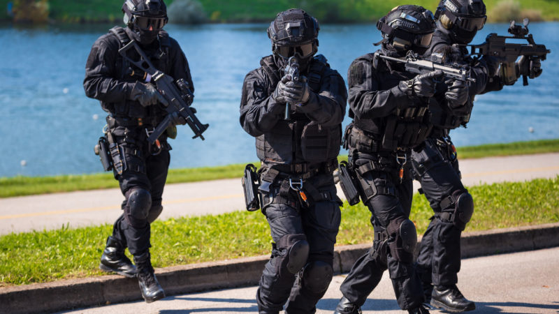 Special forces tactical team of four in action, unmarked and unrecognizable swat team